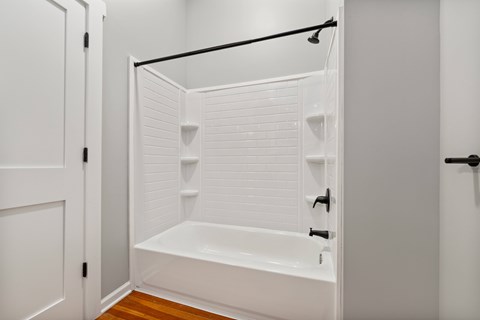 A white bathroom with a tub and a shower.
