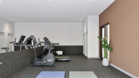 A gym room with a row of treadmills and a blue exercise mat.