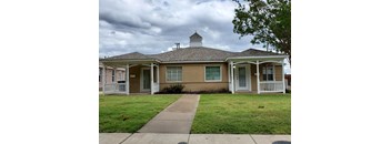 A house with a brown roof and white trim.