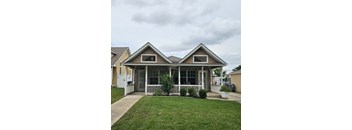 A house with a front porch and a white fence.