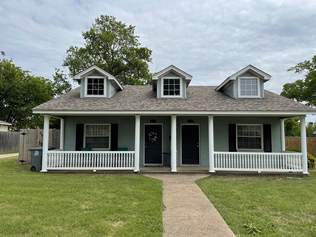 A house with a grey roof and a green front.