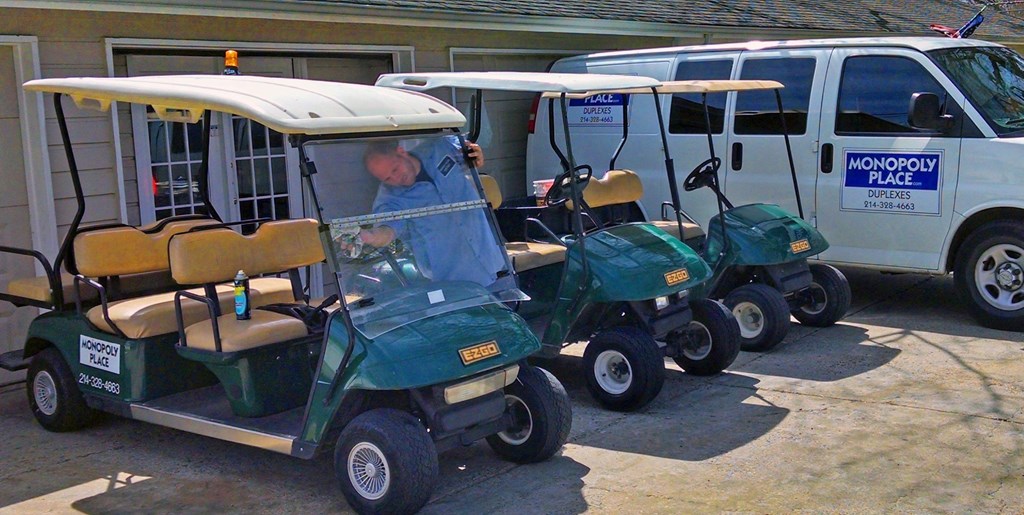 A man is standing behind a green golf cart.