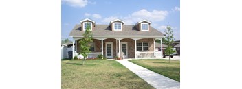 A house with a white picket fence and a tree in front.
