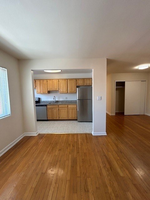 A kitchen with wooden cabinets and a refrigerator.