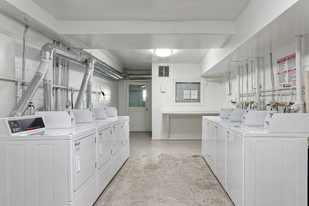 A clean, white industrial room with multiple machines and pipes.