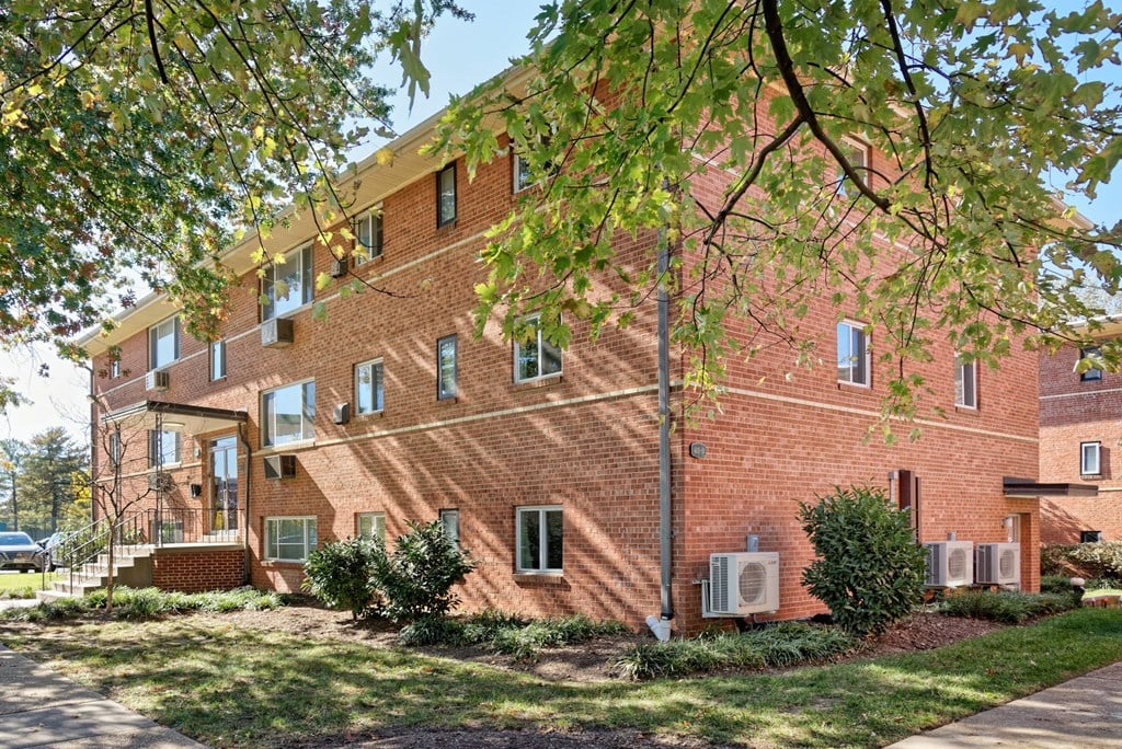 A red brick building with trees in front.