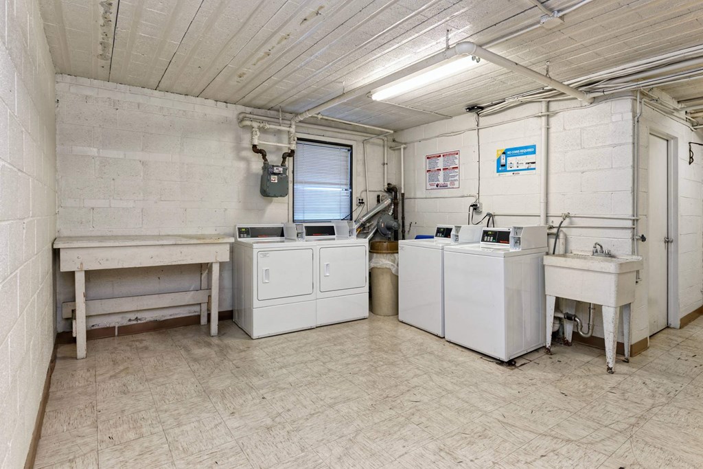 A clean, white industrial room with a table, cabinets, and a machine.
