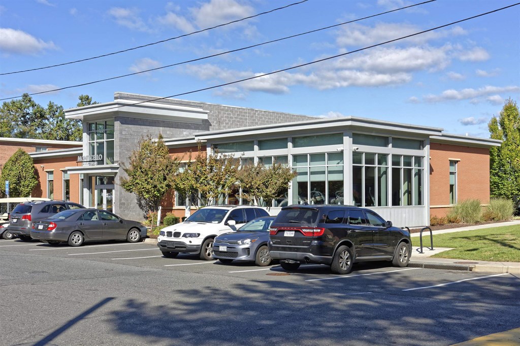 A parking lot with cars and a building in the background.
