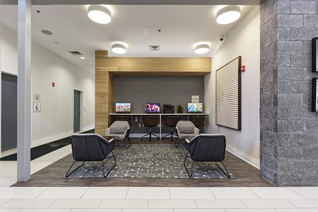 A room with a row of chairs and a screen on the wall.