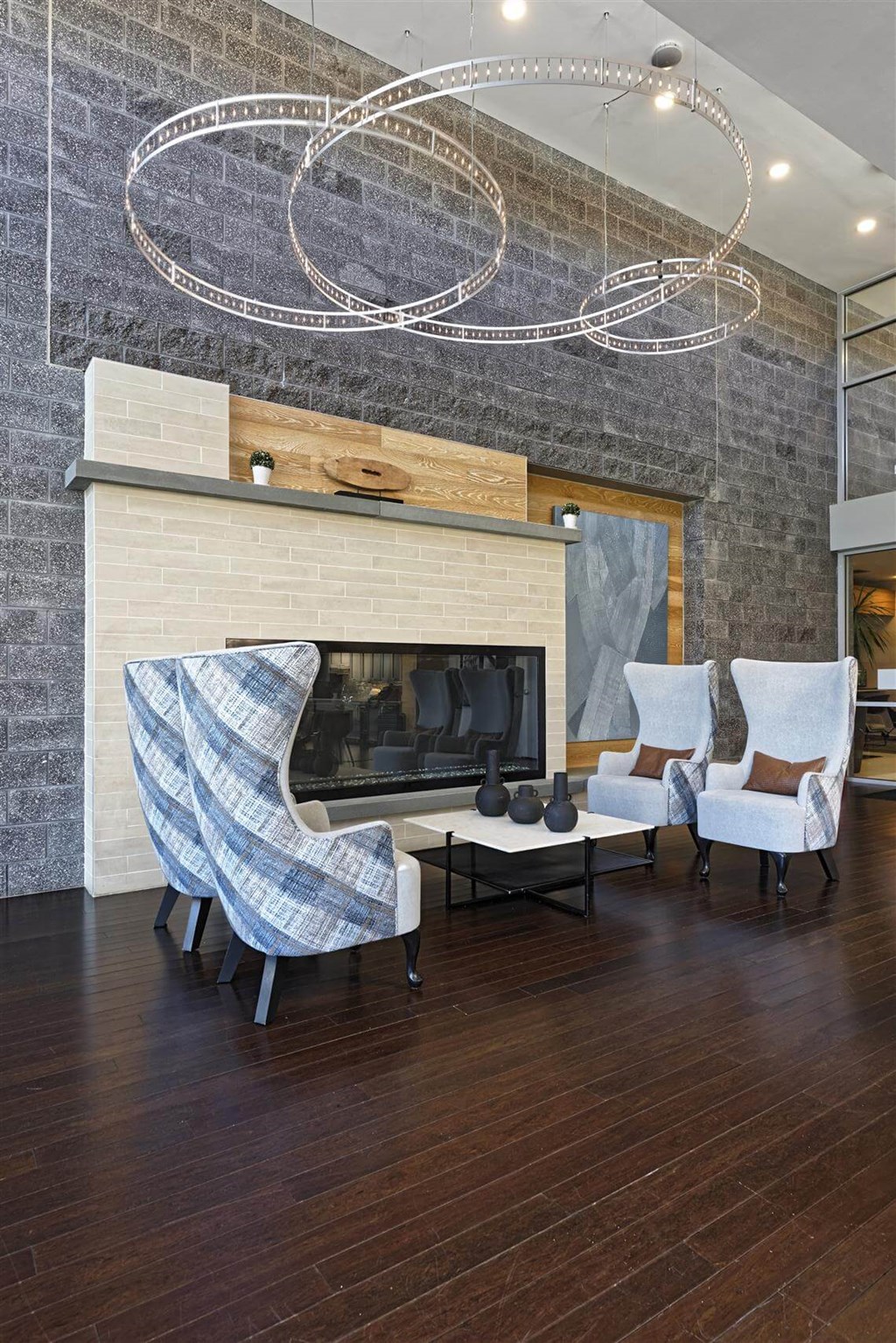 A modern living room with a fireplace and two chairs.