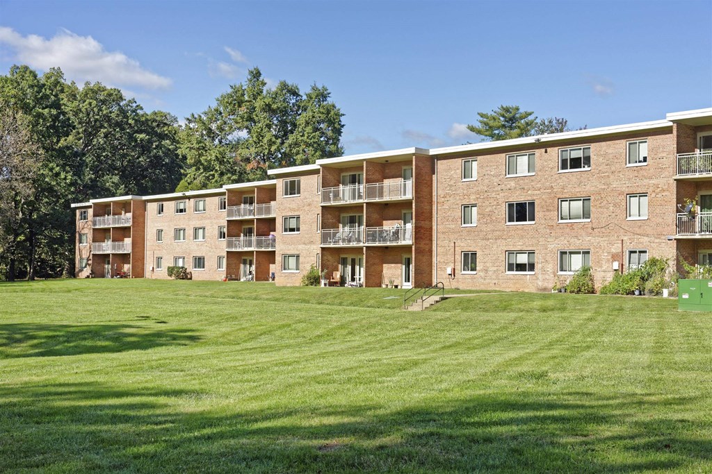 A large apartment complex with a green lawn in front.