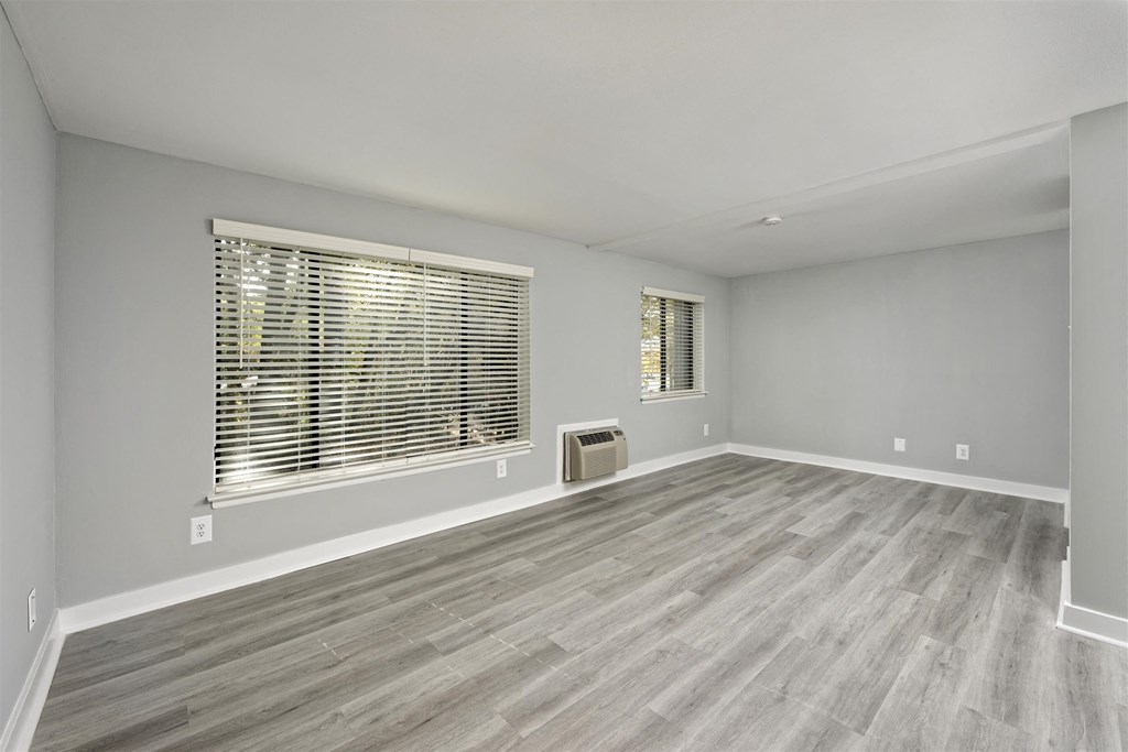 A room with a window and wooden flooring.