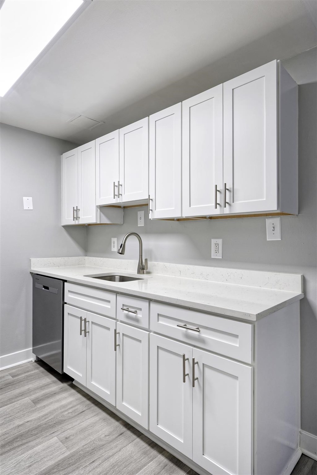 A kitchen with white cabinets and a white countertop.