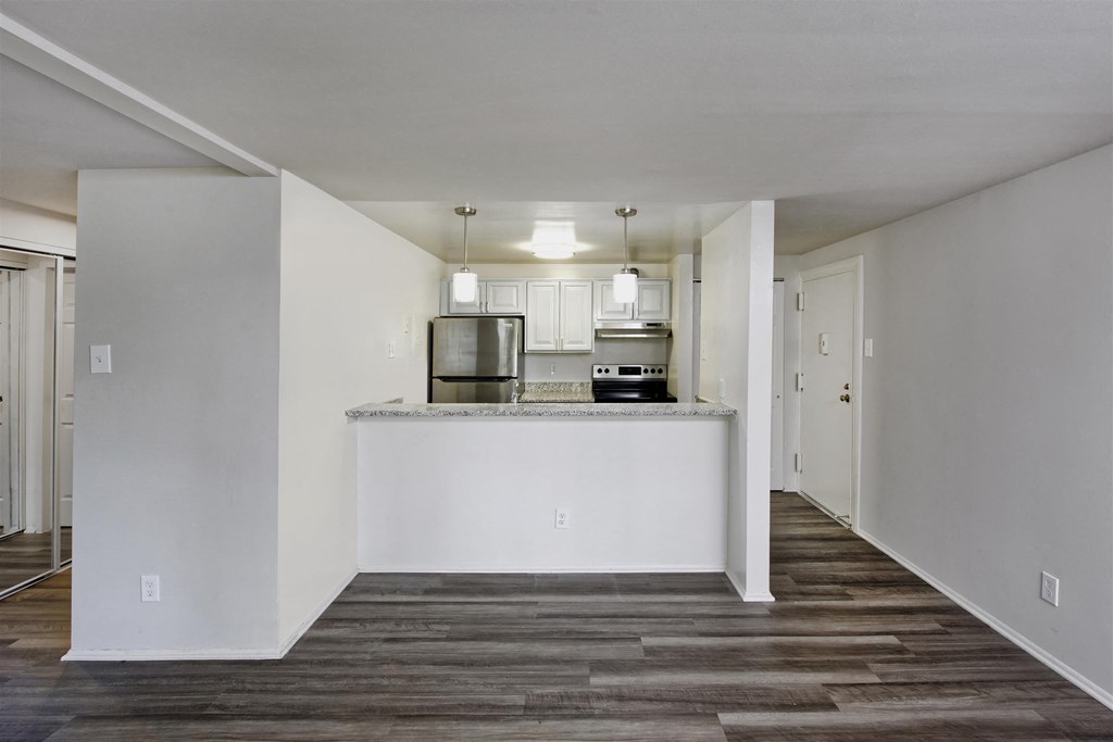 A kitchen with white cabinets and a white island with a countertop.