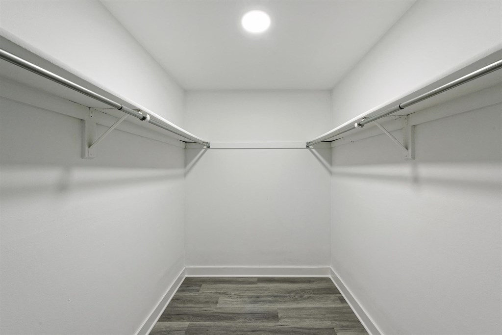 A long hallway with a wood floor and white walls.