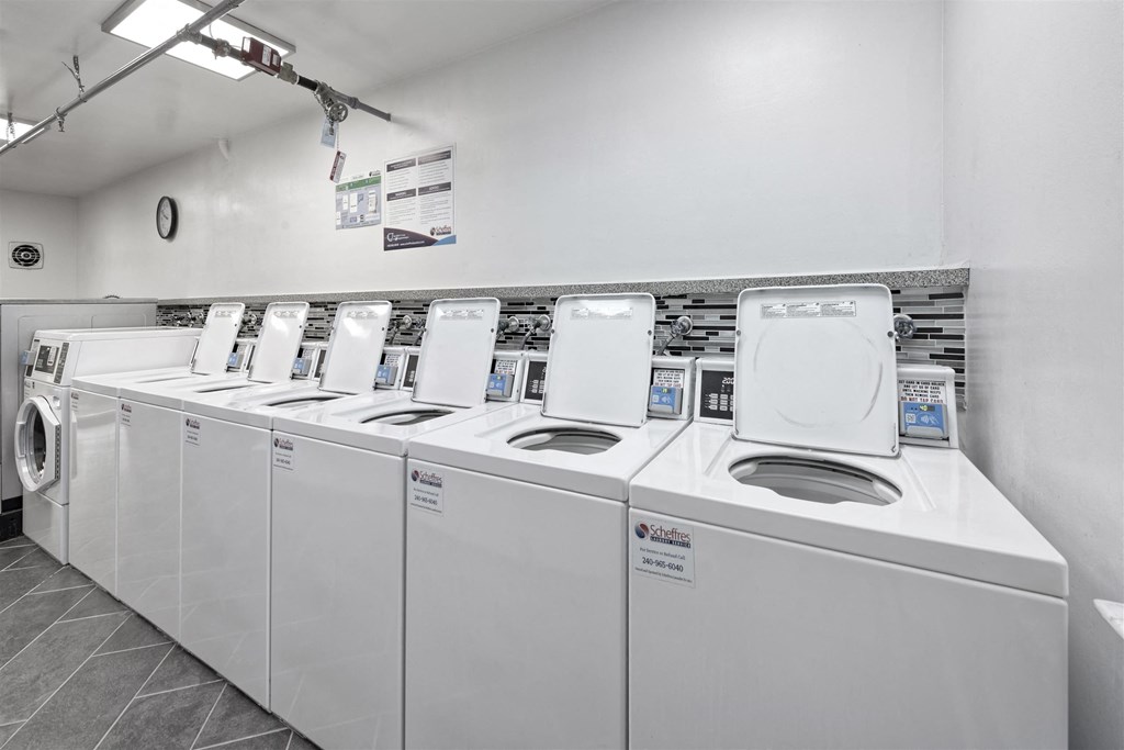 A row of white washing machines in a laundromat.