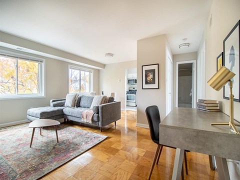 A living room with a grey couch and a grey table.