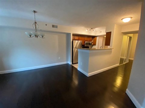 A room with a kitchen in the background and a white counter in the foreground.