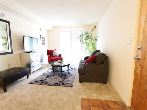 A living room with a red chair and a grey couch.