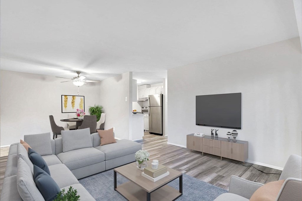 A living room with a grey couch, a coffee table, and a flat screen TV.