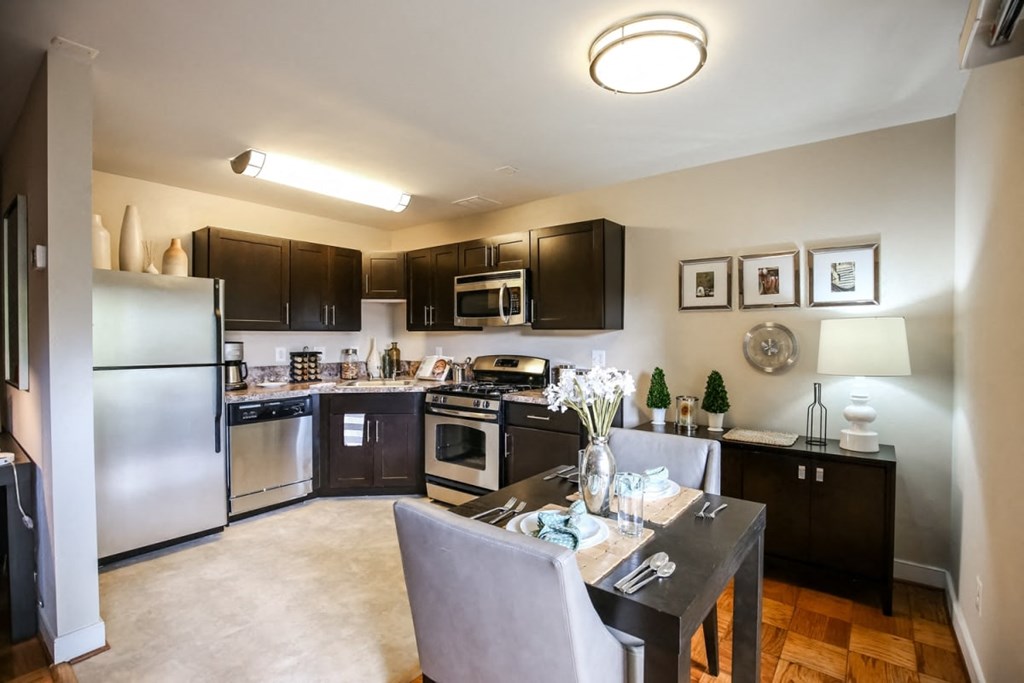 A kitchen with a table and chairs in the middle of it.