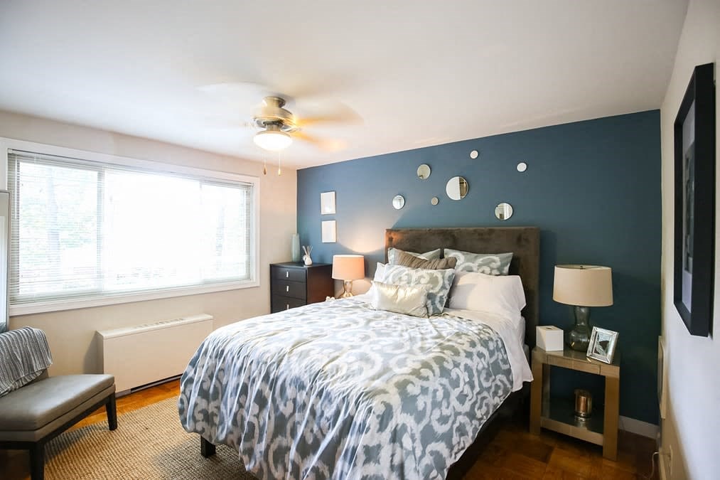A bedroom with a bed, nightstands, and a ceiling fan.
