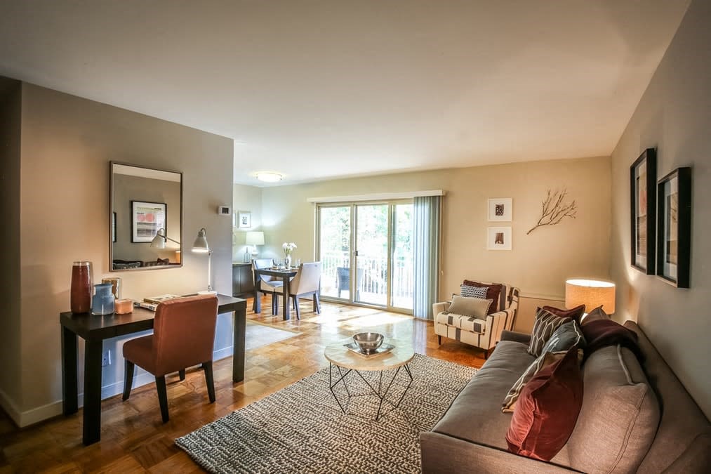 A living room with a couch, chairs, and a dining table.