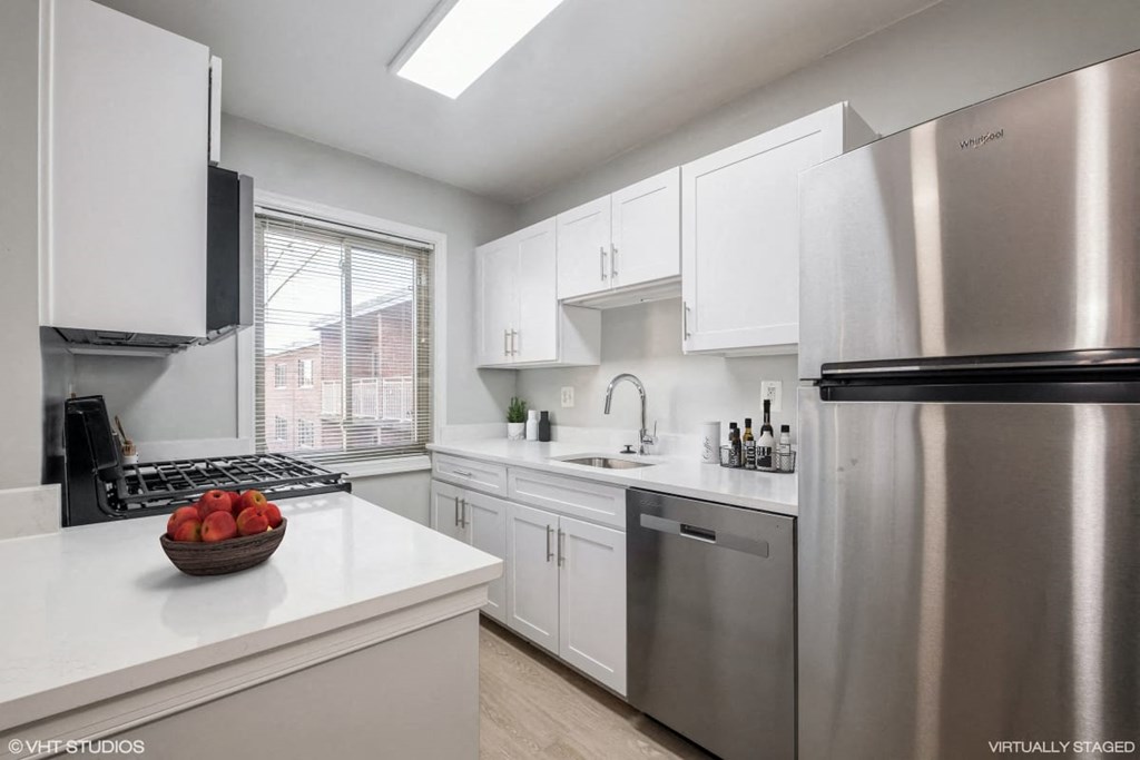 A modern kitchen with stainless steel appliances and white cabinets.