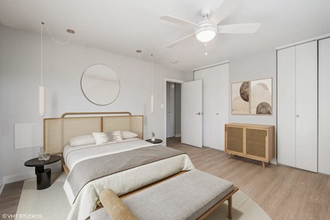 A bedroom with a large bed and a wooden headboard.