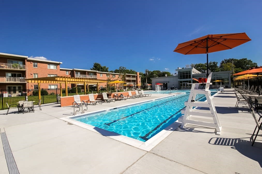 A swimming pool with a ladder and sunshades.