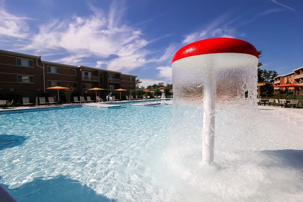 A water fountain in the middle of a pool.