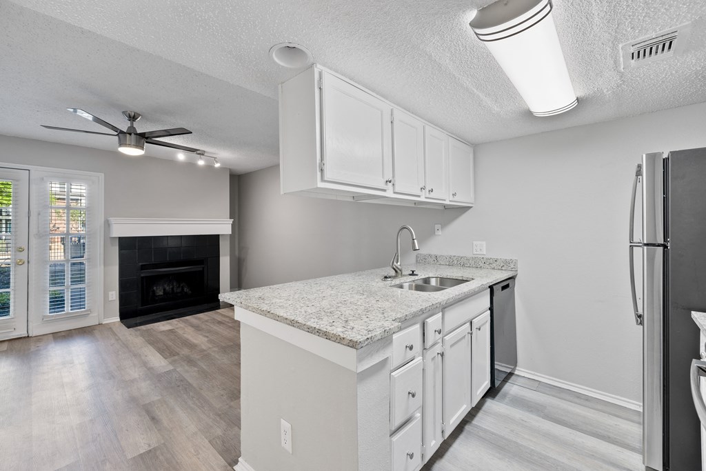 A kitchen with a white countertop and a black refrigerator.