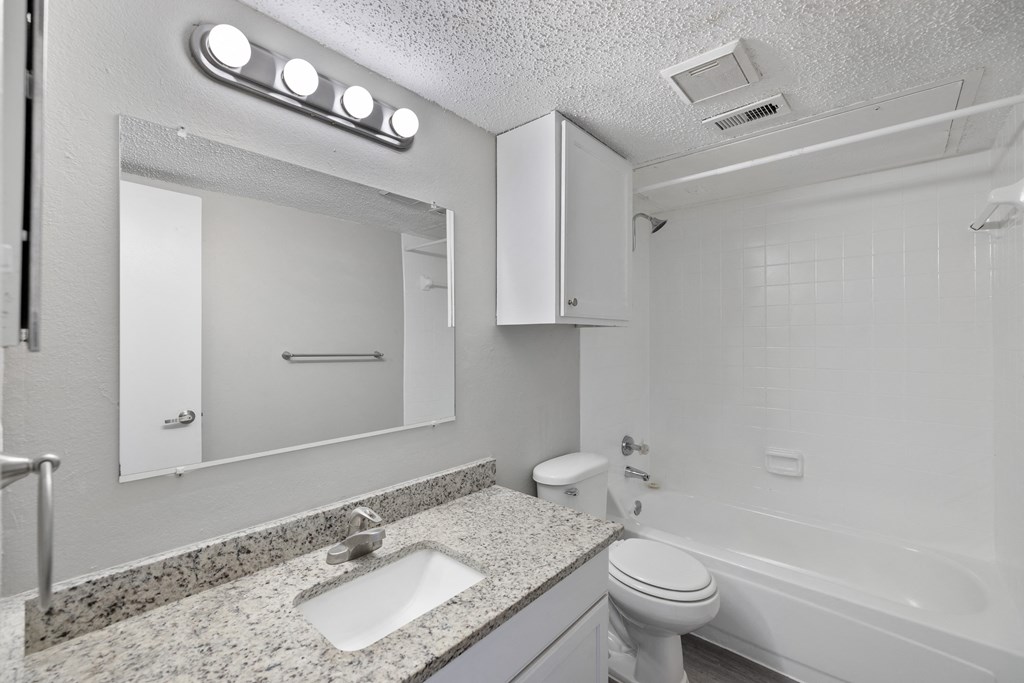 A white bathroom with a sink, toilet, and bathtub.