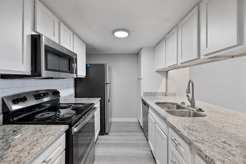 A kitchen with granite countertops and stainless steel appliances.