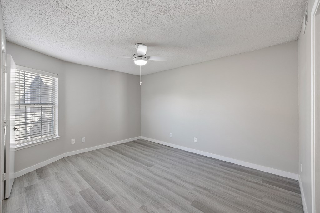 A room with a window and a ceiling fan.