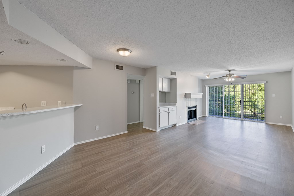 A spacious living room with a fireplace and sliding glass doors.
