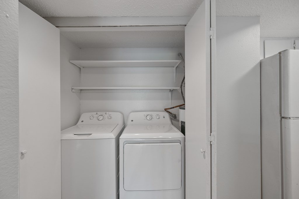 A small laundry room with a washer and dryer.