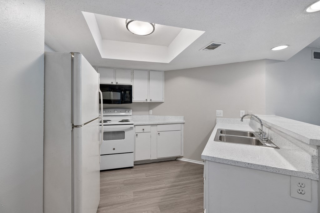 A modern kitchen with white appliances and cabinets.