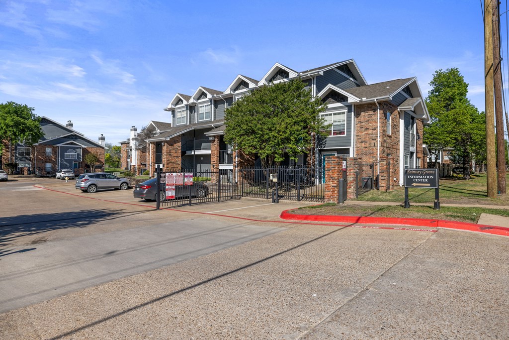 A street view of a residential area with a signboard in the foreground.