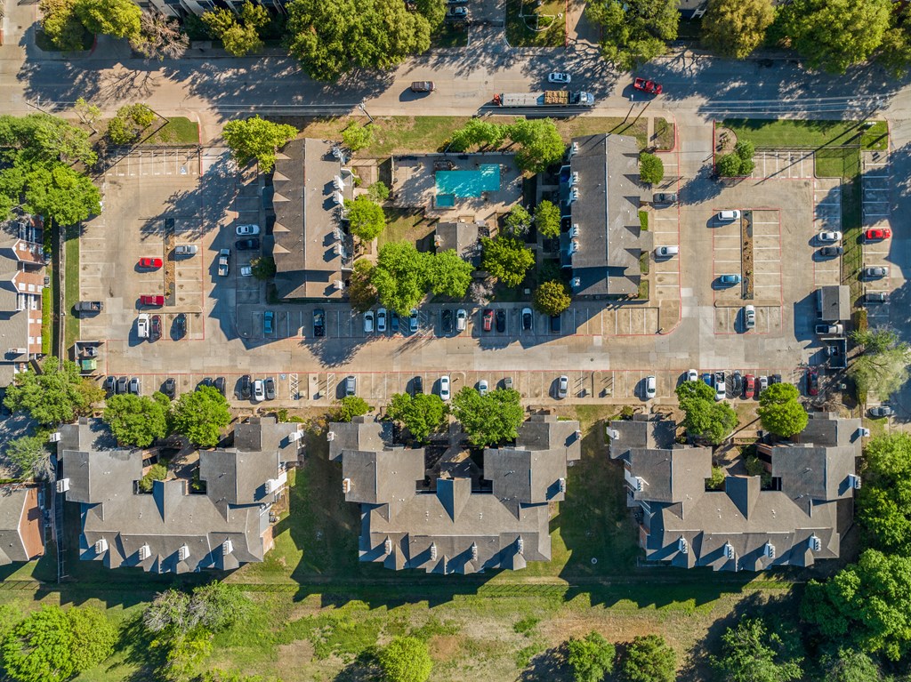 An aerial view of a residential area with houses and cars.