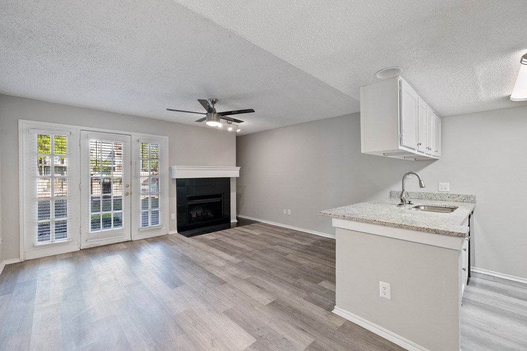 A kitchen with a fireplace and a fan on the ceiling.