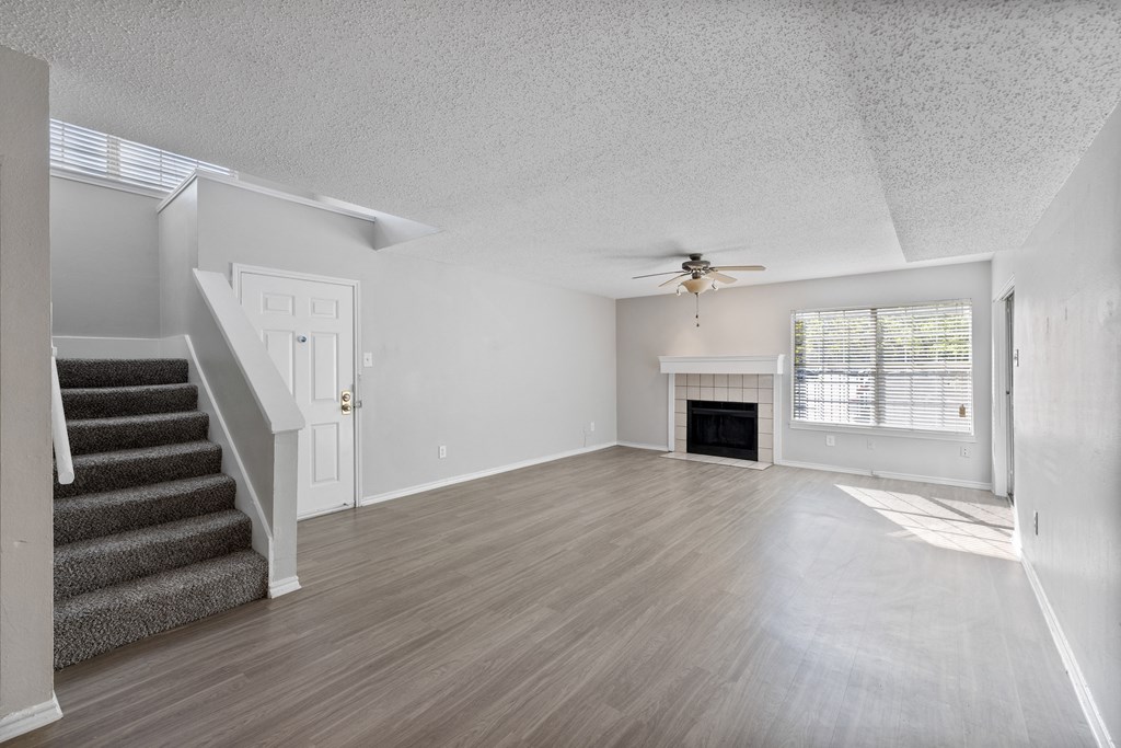 A spacious living room with a staircase leading to the upper floor.