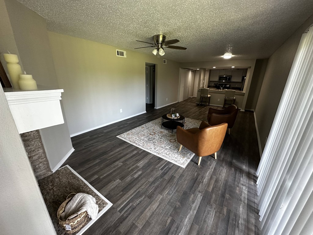 A living room with a fireplace and a ceiling fan.