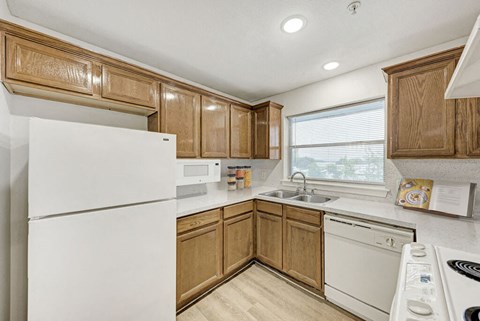 A kitchen with wooden cabinets and white appliances.