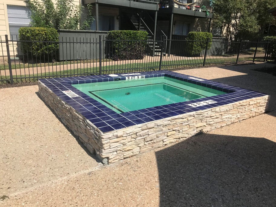 A small pool surrounded by a stone wall.
