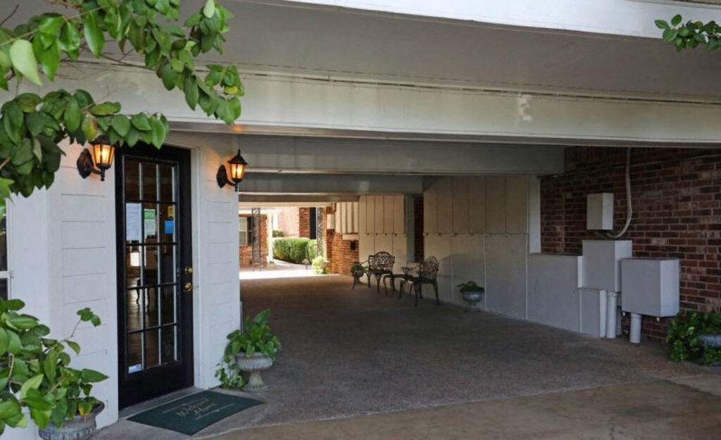 A garage with a black door and a white wall.