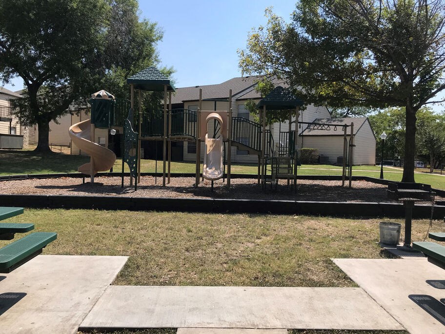 A playground with a slide, swings, and a climbing structure.