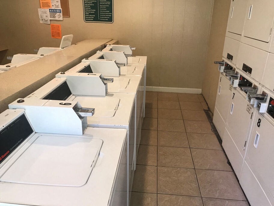 A row of white copiers are lined up in a room.