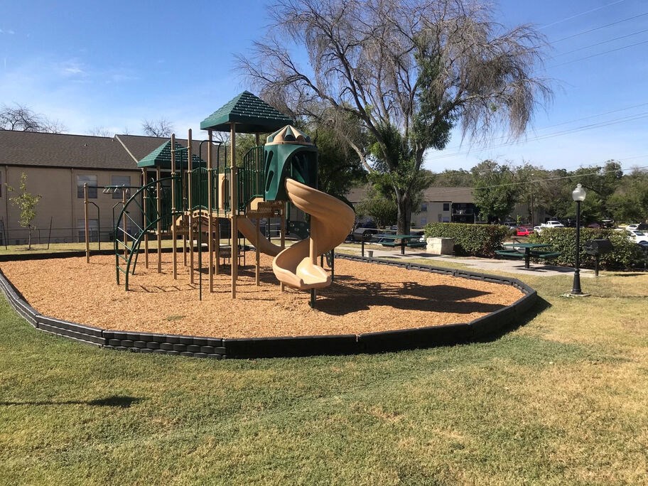 A playground with a slide and a green canopy.