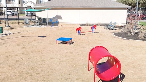 A red chair is in the foreground of a playground.